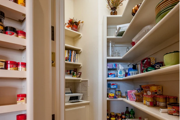A custom home walk-in pantry with ingredients on the shelves