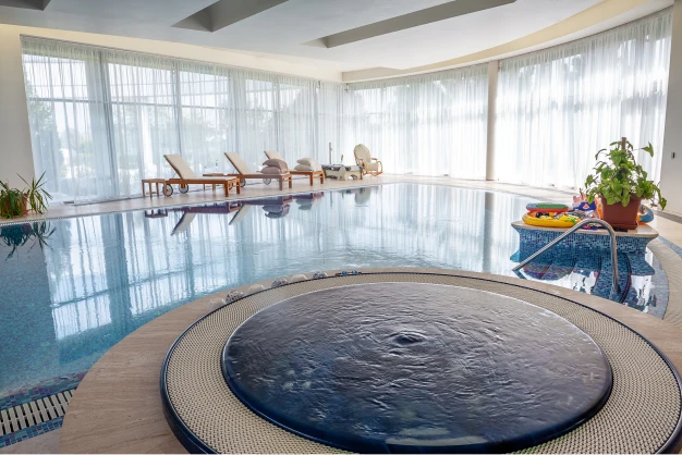 Indoor pool with lounge chairs in the background