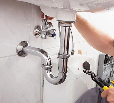 "Plumber fixing sink drain pipe."