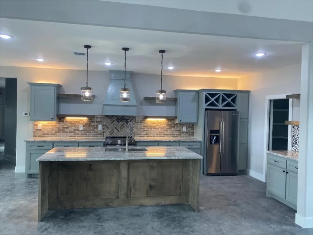 Modern kitchen with island and lighting.