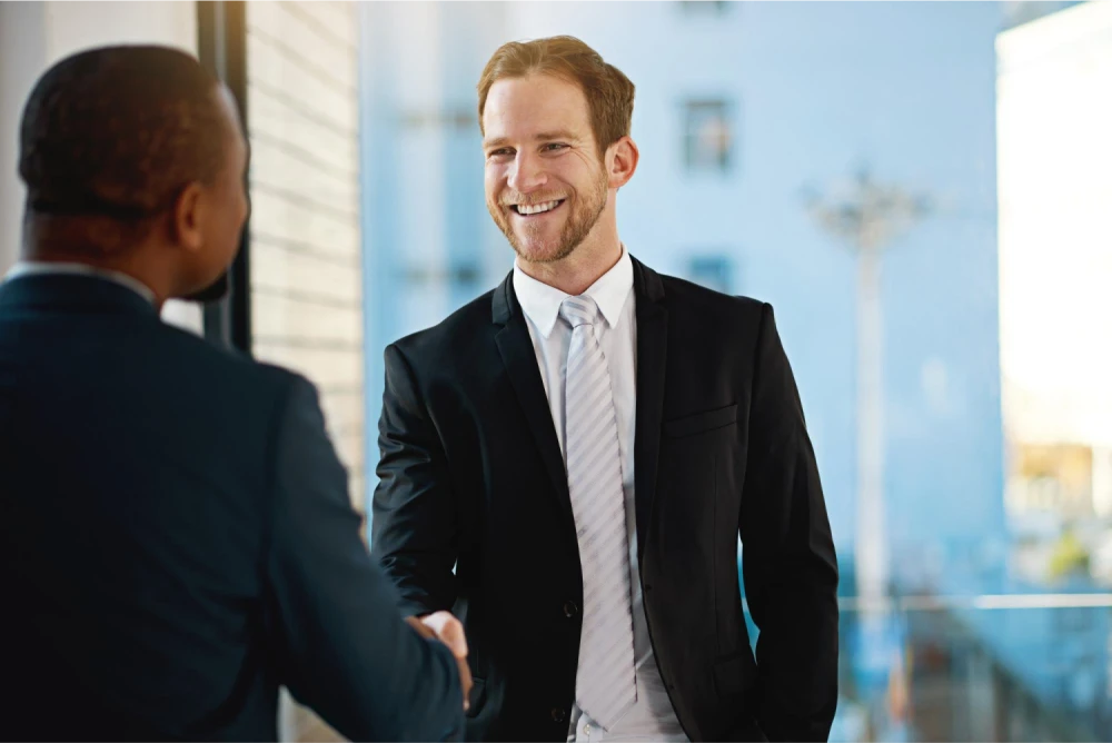 Businessman shaking hands with another person, signifying a successful business deal.