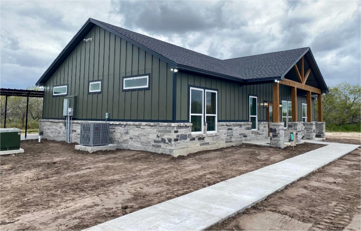 Green house with stone siding and walkway.