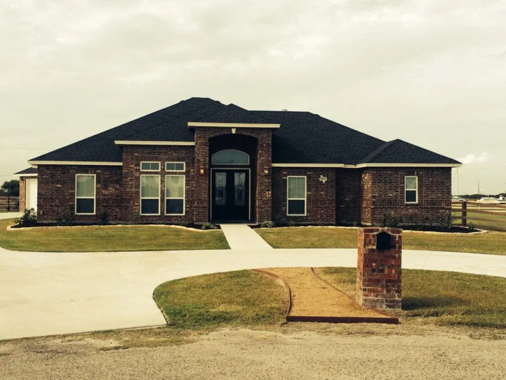 Single-story brick house with black roof.